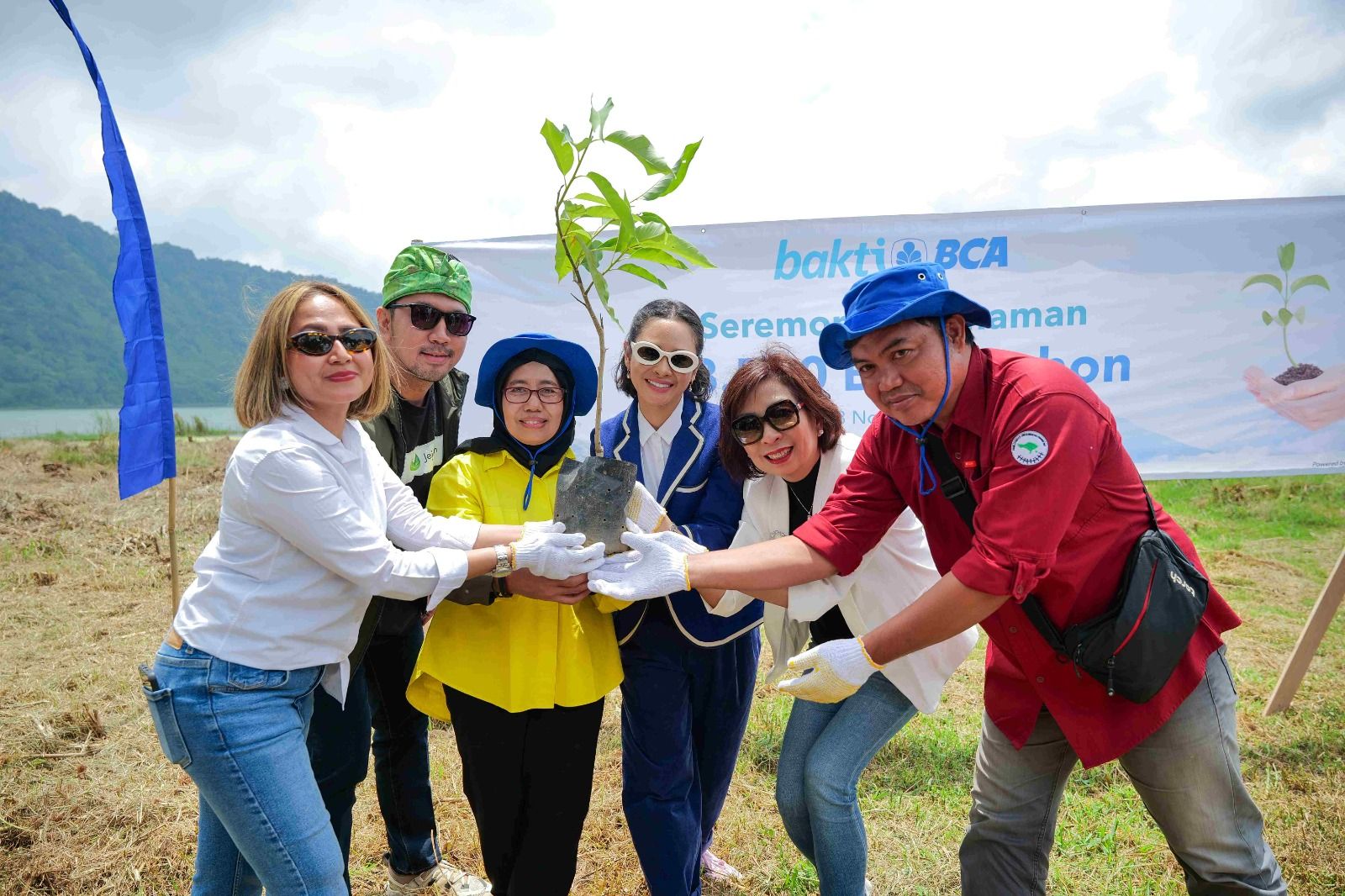 Committed to Preserving the Environment, BCA Takes Green Action by Planting 38,500 Trees in Bali - Director of Islamic Financing at the Directorate General of Budget Financing and Risk Management (DJPPR) of the Indonesian Ministry of Finance Dwi Irianti Hadiningdyah (third left), representative from the Bali I Provincial Environment and Forestry Office I Gusti Ketut Wiguna (right), BCA EVP of Corporate Communication & Social Responsibility Hera F. Haryn (left), BCA EVP of Wealth Management Ugahary Yovvy Chandra (second right), CEO of Jejakin Arfan Arlanda (second left), dan singer Andien (third right) during a tree-planting ceremony in Bali on Thursday (23/11). PT Bank Central Asia Tbk (BCA) took green action by planting 38,500 trees in six villages in Denbukit, Buleleng, Bali. The activity is one of the BCA’s commitments to always actively participate in environmental conservation efforts.